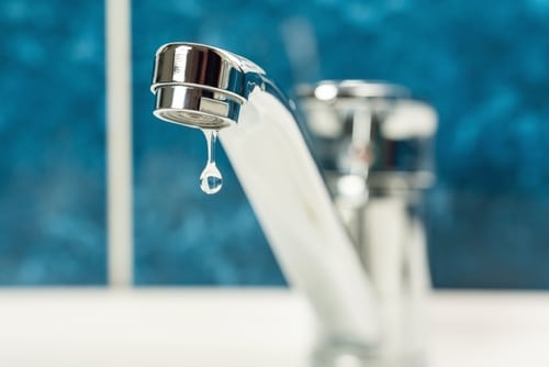 A drop of water dripping from a leaky faucet