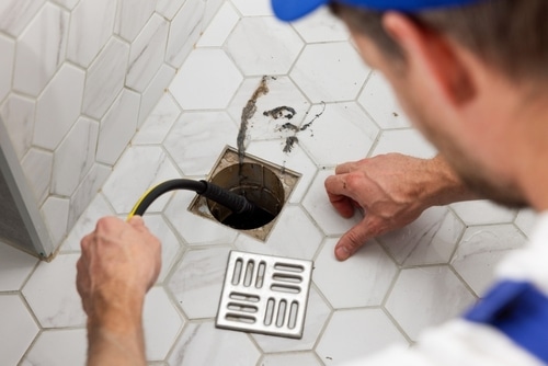 A plumber uses hydro jetting to clear a clogged drain.