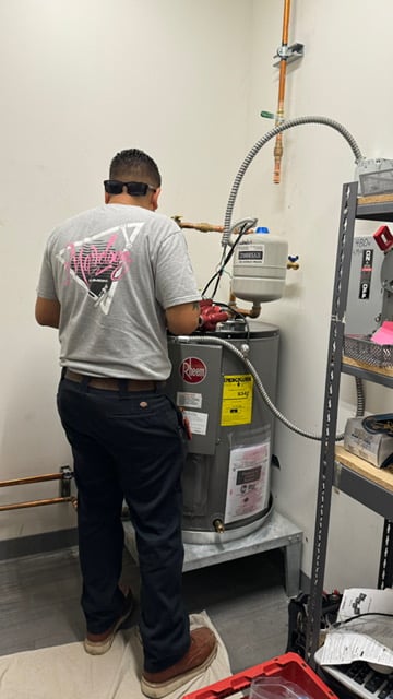A Marvelous Plumbing technician repairs a water heater.
