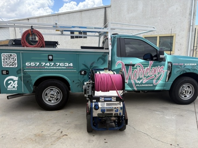 A Marvelous Plumbing truck parked outside of a business.