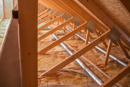An attic with pipes laid on top of insulation